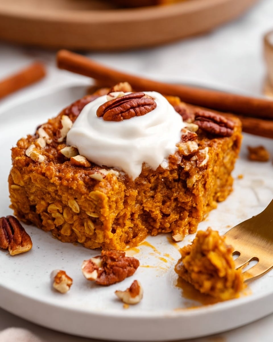 A square piece of baked oatmeal sits on a white plate with a white marbled texture surface below, showing a soft, textured orange-brown layer made of oats and pumpkin or sweet potato. On top, there is a dollop of white cream with a few small to medium pecan nut pieces scattered over it. A gold spoon with a bite of the oatmeal rests on the plate's right side, near the piece. Two cinnamon sticks are placed in the blurred background. Photo taken with an iphone --ar 4:5 --v 7