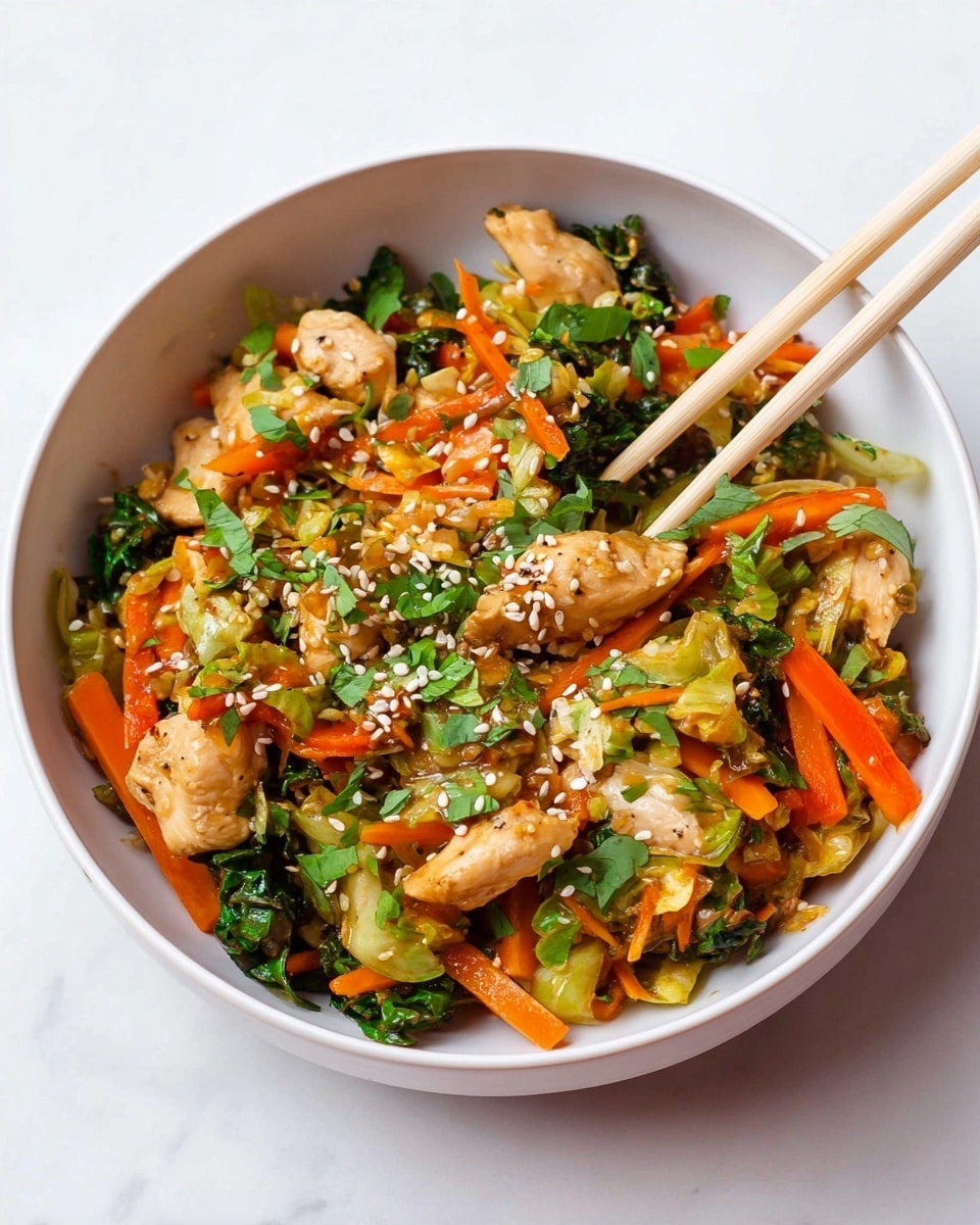 The dish is served in a white bowl on a white marbled surface, filled generously with stir-fried pieces of light brown chicken mixed with bright orange carrot strips, light green shredded cabbage, and small green herbs scattered throughout. The top is sprinkled with pale beige sesame seeds, adding texture and contrast. A pair of light wooden chopsticks is placed inside the bowl, held by a woman's hand, reaching into the colorful mix of ingredients. The overall look is fresh, vibrant, and healthy with distinct layers of chicken, vegetables, and seeds all softly mixed together. Photo taken with an iphone --ar 4:5 --v 7