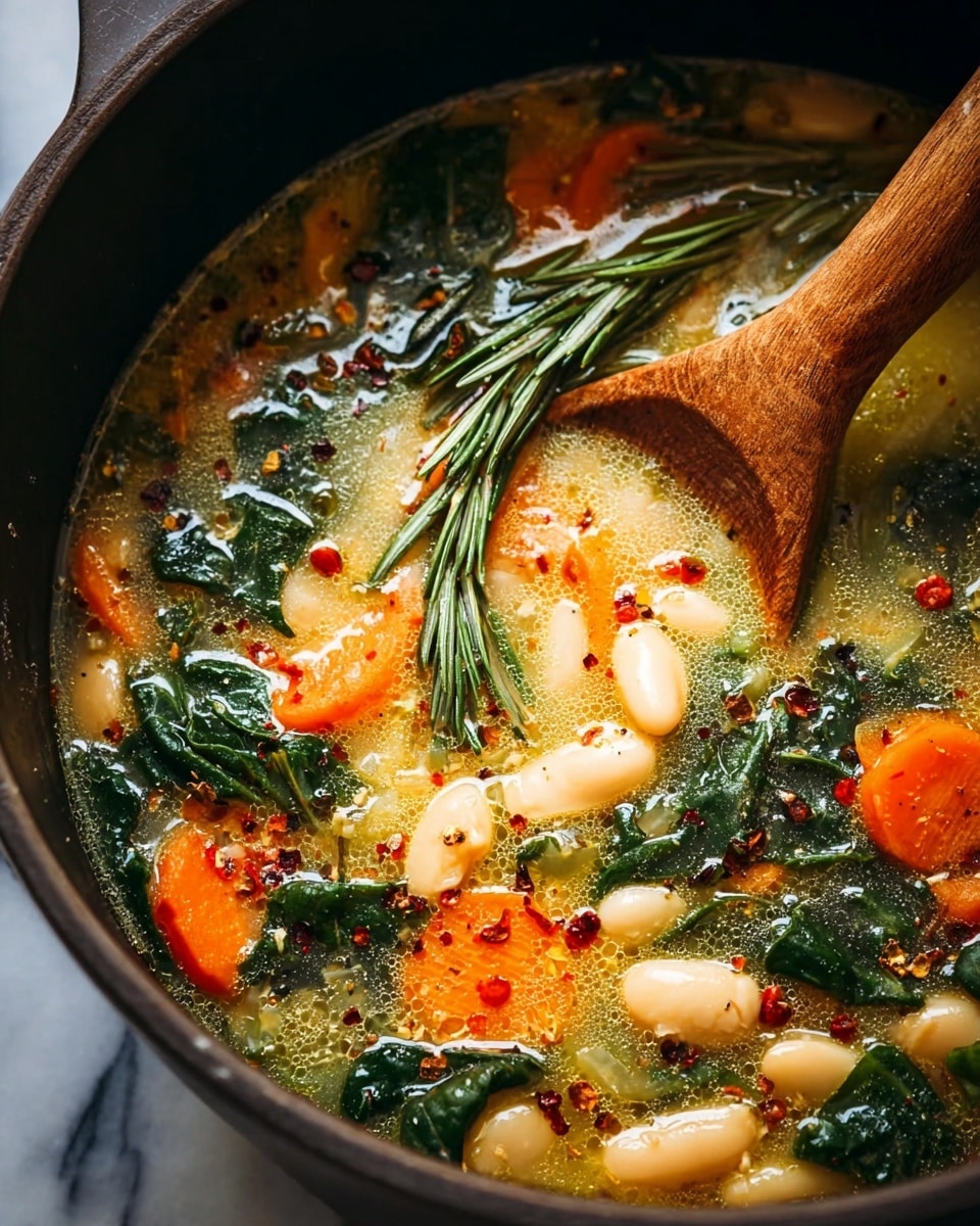 A close-up of a soup in a dark pan showing several layers: the top layer has bright orange carrot slices, pale beige beans, dark green leafy vegetables, and fresh rosemary sprigs. The soup broth is light yellow with a slightly oily surface, sprinkled with red chili flakes and ground black pepper. A wooden spoon is partially dipped in the soup on the right side, lifting some beans and greens. The texture looks thick and hearty with visible seasoning floating on top. The background is a white marbled texture. photo taken with an iphone --ar 4:5 --v 7