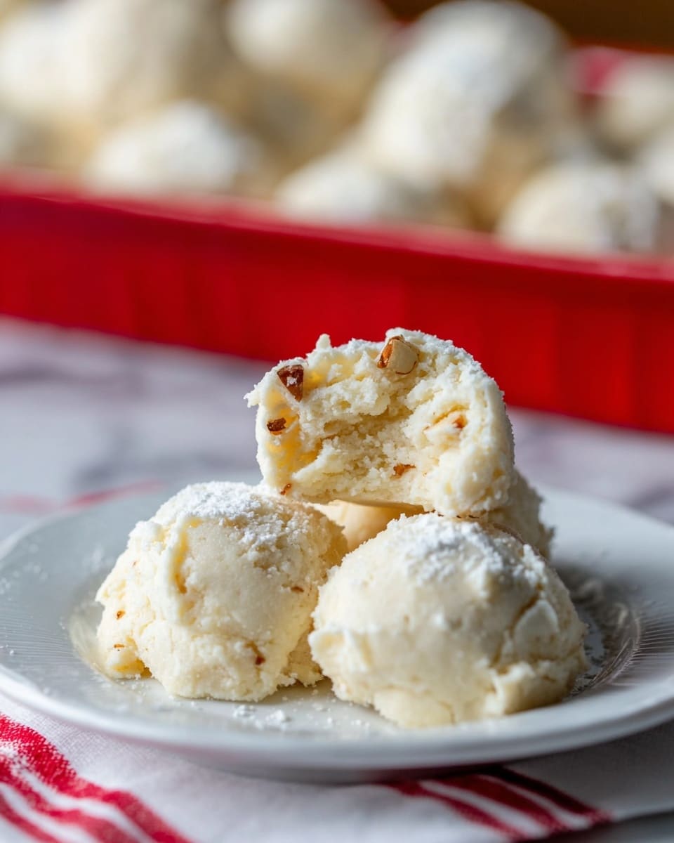 The image shows about fifteen rounded scoops of cookie dough arranged closely in a silver foil baking dish and several more scoops on a baking tray lined with parchment paper. Each dough scoop looks rough and crumbly with a pale beige color mixed with small off-white chunks, giving a textured appearance. The scoops are imperfectly shaped, some slightly flattened at the sides where they touch each other. The background includes a wooden surface partly visible beneath the foil dish and tray, all with clear lighting highlighting the rough texture of the dough. photo taken with an iphone --ar 4:5 --v 7
