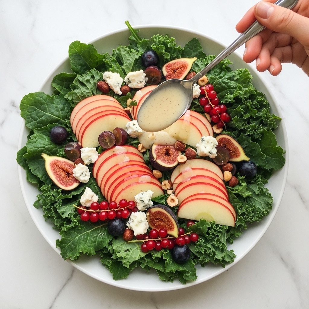 A white bowl filled with a fresh salad that has three main layers: the bottom layer is green leafy kale, the middle layer contains halved dark purple figs with soft light brown insides, and the top layer includes thin, curved slices of red-skinned pear, chunky white cheese pieces with crumbly texture, whole and halved dark grapes, small clusters of bright red currants, and scattered chopped nuts with light brown skin. Next to the bowl, on a white marbled surface, is a clear glass jar filled with a thick, pale yellow dressing speckled with black seeds, with a metal spoon inside. Small red currant clusters lie nearby. Photo taken with an iphone --ar 4:5 --v 7