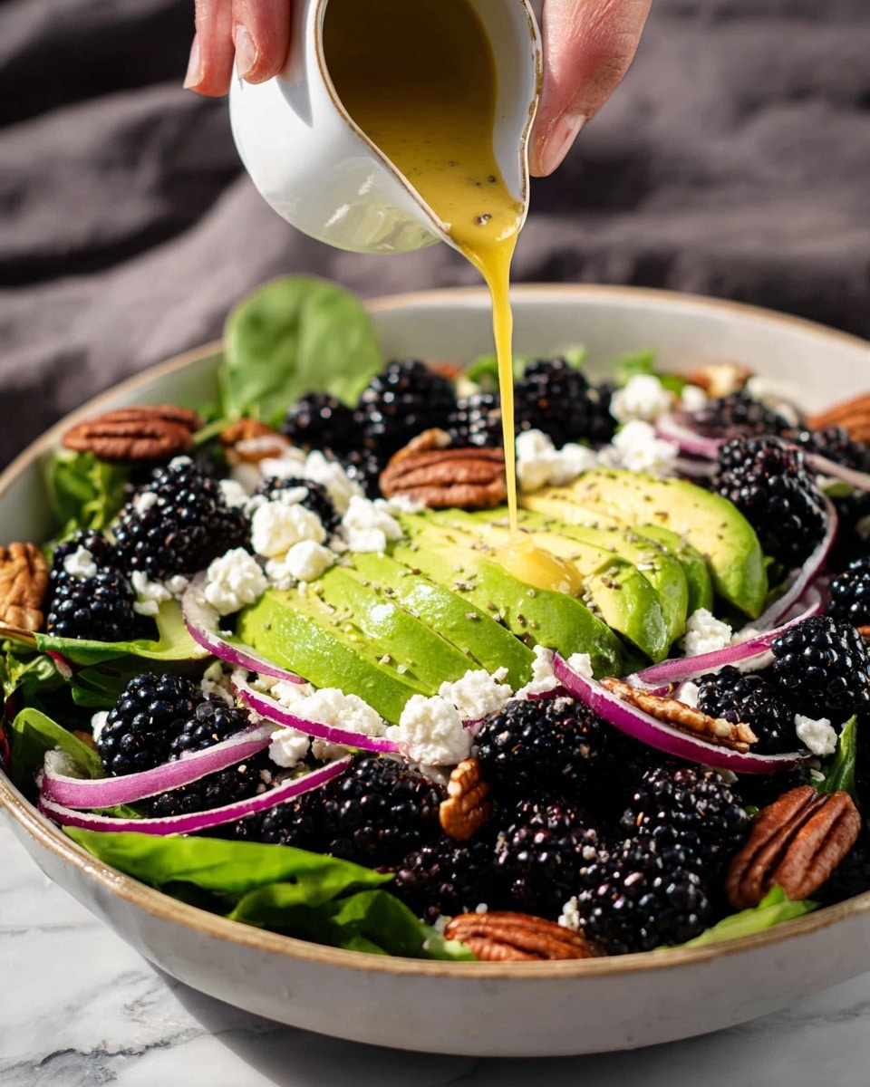 The image shows two white bowls filled with fresh salad placed on a white marbled surface. Each salad has several layers: a base layer of mixed green leaves including spinach and arugula, topped with slices of green avocado arranged neatly on one side, thin rings of pink pickled onions scattered throughout, and whole blackberries clustered in small groups. There are crumbles of white cheese sprinkled evenly and pieces of brown pecans scattered around. The layers are bright and fresh with some black pepper and sea salt flakes sprinkled on top for seasoning. A blue napkin with two silver forks is placed near the bottom left corner, adding to the setting. Photo taken with an iphone --ar 4:5 --v 7