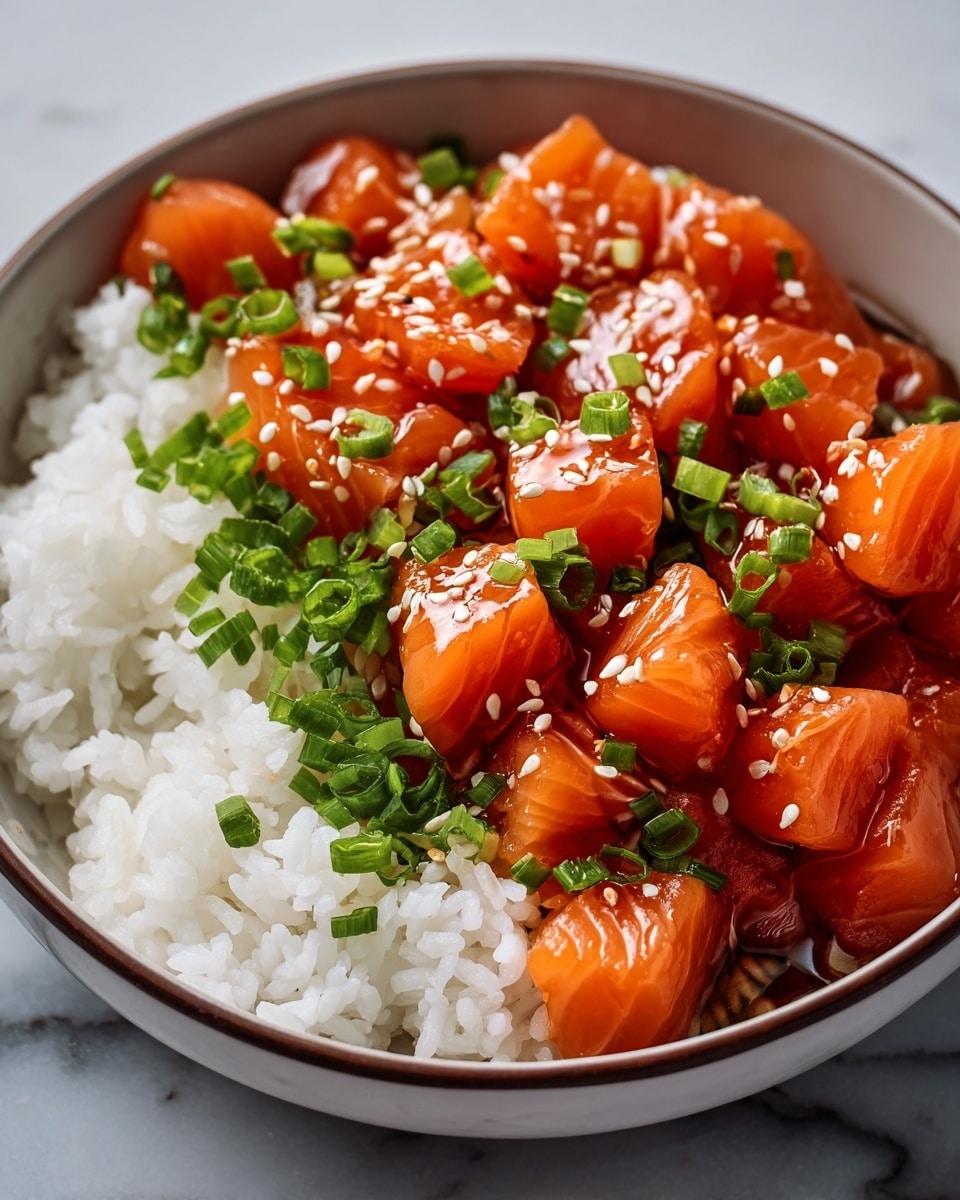 A white bowl filled with several layers of fresh, glossy orange salmon pieces cut into bite-sized cubes placed on top, sprinkled with small white sesame seeds and chopped bright green spring onions. Next to the salmon is a neat mound of soft white rice grains, and behind them is a bed of dark green leafy vegetables, adding freshness and contrast to the dish. The bowl sits on a white marbled surface, and the colors of the food create a vibrant, fresh look. Photo taken with an iphone --ar 4:5 --v 7