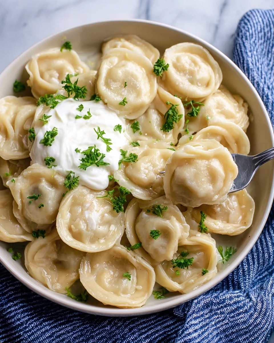 A bowl filled with many round dumplings that have a light beige, soft dough texture, each folded with visible edges and some with small wrinkles. On top, there is a dollop of white sour cream with a smooth and creamy texture. Bright green chopped parsley is sprinkled evenly over the dumplings and sour cream, adding fresh color contrast. The bowl is white with a thin blue rim, and the background is a white marbled texture. A silver fork is visible on the right side, lifting one dumpling. Photo taken with an iphone --ar 4:5 --v 7