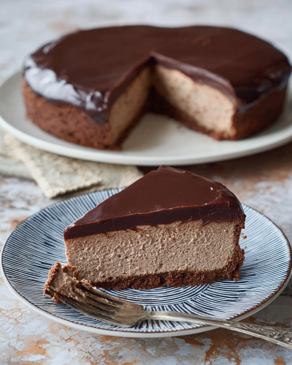 A slice of chocolate mousse cake rests on a white plate with blue circular patterns; it has two main layers: the bottom layer is a soft, light brown mousse with a fluffy texture, and the top layer is a thick, smooth, and shiny dark chocolate ganache. The slice shows some small crumbs around its base, and a piece of mousse cut from the cake sits on a silver fork placed in front of the slice. The scene is set on a white marbled surface, highlighting the cake's textures and colors. photo taken with an iphone --ar 4:5 --v 7