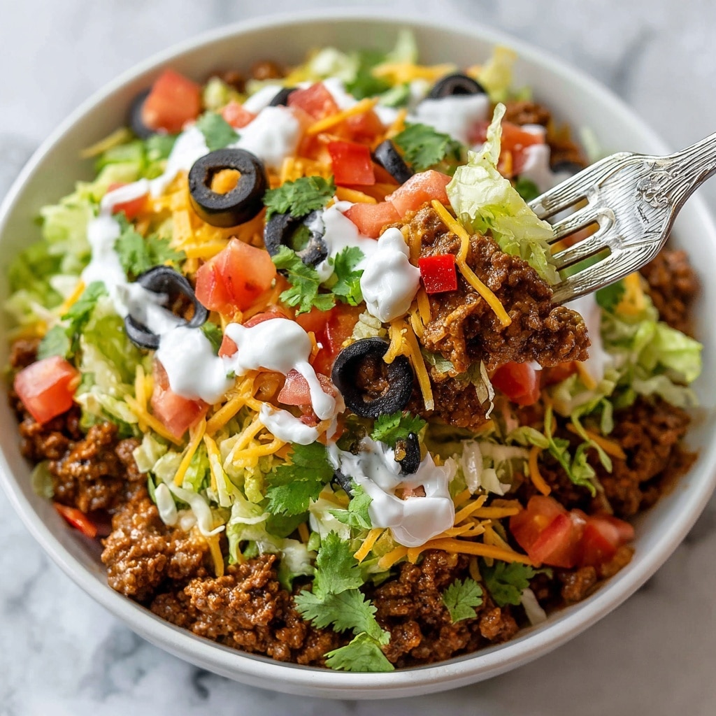 An oval white dish contains a multi-layered taco dip with one large scoop missing from the center. The bottom layer is a brown, creamy bean mixture, topped with a white creamy layer spread evenly. On top of this are scattered shredded orange and white cheese, small chopped red tomato pieces, black olive slices, light green shredded lettuce, green jalapeño slices, and fresh green cilantro leaves, giving a colorful and textured look. The dish is placed on a white marbled surface. photo taken with an iphone --ar 4:5 --v 7